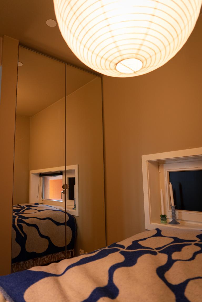 Stort garderobeskap med klesstang og skuffer i alkoven. Her er det også vindu.